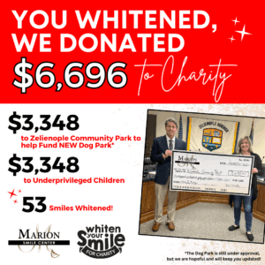 Image of Dr. Marion holding a check from the money they raised from teeth whitenings.